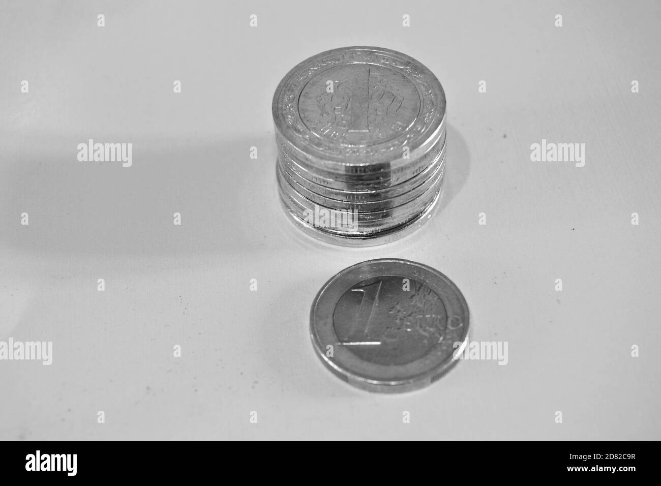 Money and currency of Turkey. Money and Groups of `One Turkish Lira` coins together and 1 euro coin. Isolated background. Black and white photo Stock Photo